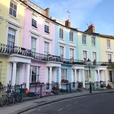 a woman walking down the street in front of multi - colored houses