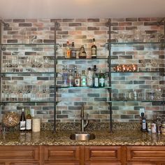 a kitchen counter topped with lots of bottles and glasses