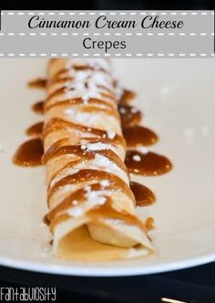 a white plate topped with crepes covered in syrup