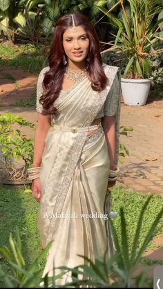 a woman in a white sari posing for the camera