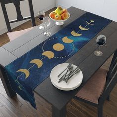 the table is set with two plates and silverware, one has an eclipse design on it