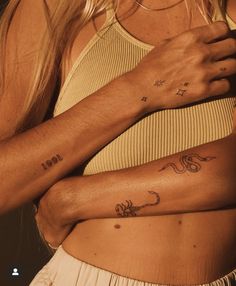 two women with matching tattoos on their arms