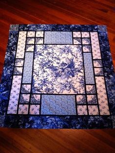 a blue and white quilt on a wooden floor