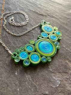 I love circles, especially concentric ones. Theres something I find soothing about groupings of them and the organic shapes they form. Thats what I tried to capture in these quilled necklaces. Each circle is made from layer upon layer of hand rolled (quilled) paper strips that are then arranged into a bib. They have been sealed twice in waterproof varnish for durability. That being said, these are not made to be submerged in water but they will hold up to daily wear nicely. This necklace has 5 s Wallpaper Film, Quilling Necklace, Paper Quilling Jewelry, Quilled Jewellery, Clay Things, Quilling Jewelry, Statement Bib Necklace, Quilling Paper, Craft Jewelry