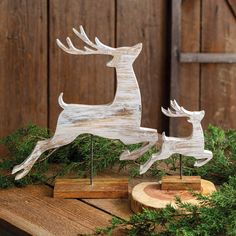 two wooden deer figurines sitting on top of a table