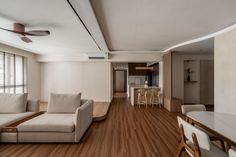 a living room filled with furniture next to a kitchen and dining room table on top of a hard wood floor