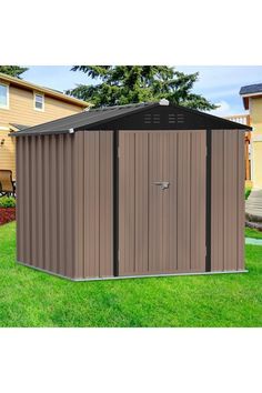 a brown and black shed sitting in the grass