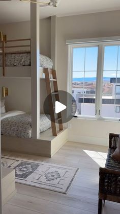 a room with two bunk beds and a chair in front of a window that looks out onto the ocean