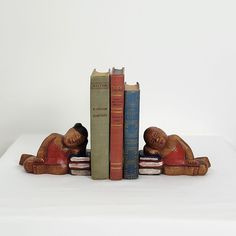 three books are stacked on top of each other in front of a statue of a man