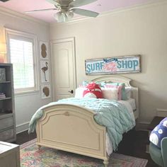 a bed room with a neatly made bed and a ceiling fan