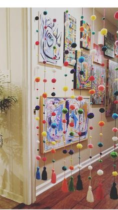 a hallway decorated with colorful pom poms hanging from the ceiling and pictures on the wall