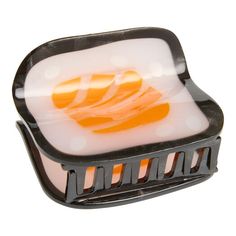 an orange and white object sitting on top of a black plastic container with holes in it