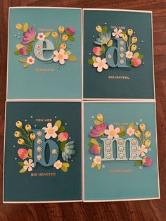 four cards with flowers and the letter e on them, all decorated in different colors