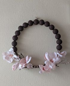 a bracelet with flowers and beads hanging on the wall