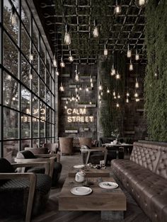 the interior of a restaurant with leather couches and tables in front of large windows