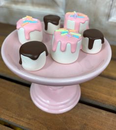 small desserts on a pink plate with chocolate and marshmallow frosting toppings