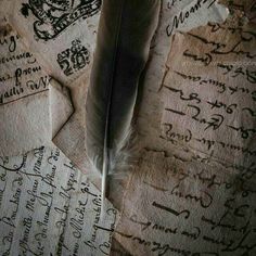 an old paper with writing on it and a feather quill resting on the top