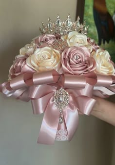 a bridal bouquet with pink and white roses in the center is being held by someone's hand