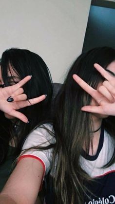 two girls with their hands in the air and one girl holding her face behind her head