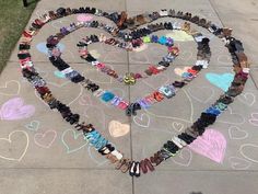 a heart made out of shoes on the sidewalk with hearts drawn in chalk and colored pencils