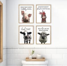 three farm animals are hanging on the wall next to a white toilet in a bathroom