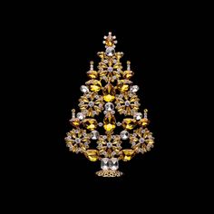 a yellow and white christmas tree made out of crystal stones on a black back ground