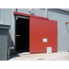 an open red door on the side of a building