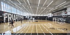 an indoor basketball court with people playing on it