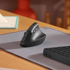 a computer mouse sitting on top of a desk next to a keyboard and mouse pad