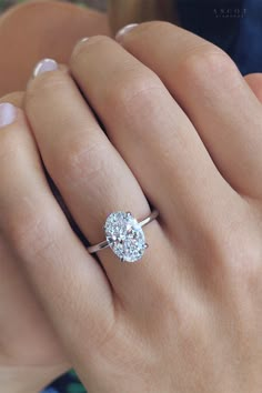 a woman's hand with a diamond ring on it