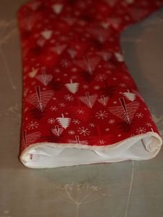 a red cloth with white snowflakes and hearts is laying on a table top