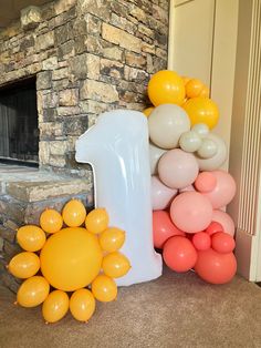 balloons are arranged in front of a stone fireplace with a large number one on it