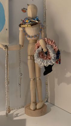 a wooden mannequin holding a doll in it's arms