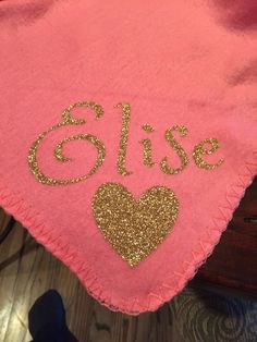 a pink blanket with gold sequins on it and the word'elise'written in cursive font