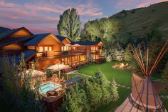 an aerial view of a log cabin with a pool and hot tub in the foreground