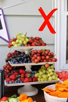 a fruit stand with grapes, strawberries, oranges and other fruits on it