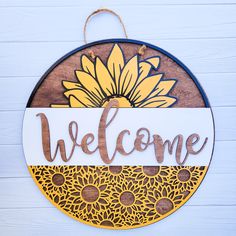 a welcome sign hanging on the side of a building with a sunflower painted on it