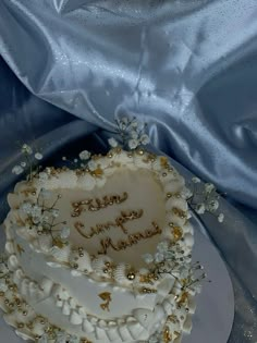 a heart shaped cake on a plate with the words happy birthday written in gold lettering