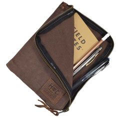 an open brown zippered pouch with pens and pencils in it on a white background