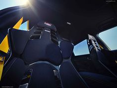 the sun shines brightly through the windshield of a sports car with black and yellow seats