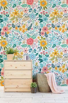 a flowery wallpaper with colorful flowers and plants on the floor next to a chest of drawers