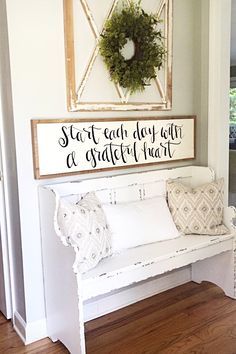 a white bench sitting in front of a framed sign