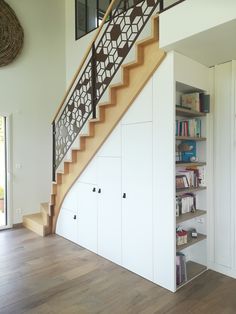 a staircase with bookshelves and cabinets under it