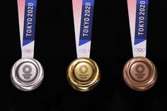 three gold, silver and bronze medals are shown in front of a black background with the olympic logo