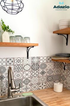 a kitchen sink with wooden counter tops and shelves on the wall above it, next to a stainless steel dishwasher