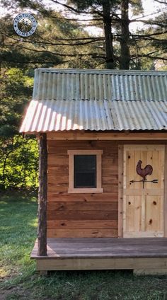 a small wooden house with a chicken on the front door and side porch, surrounded by trees