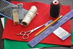 sewing supplies laid out on top of a red mat with measuring tape, scissors and thread