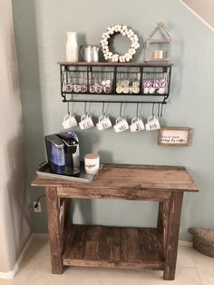 a wooden table with coffee cups on it next to a shelf filled with mugs