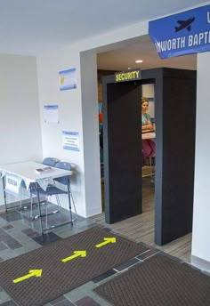 an empty room with yellow caution tape on the floor and two tables in front of it