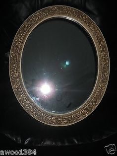 a round mirror sitting on top of a black bag